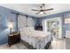 Bedroom with a floral quilt, sliding barn doors, and a view of an outdoor patio at 8719 Gaillard Ave, North Port, FL 34287