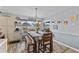 Bright dining area with a modern chandelier, gray walls, and a window seat overlooking the fenced backyard at 8719 Gaillard Ave, North Port, FL 34287