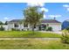 Charming single-story home with lush green lawn and mature landscaping on a beautiful sunny day at 8719 Gaillard Ave, North Port, FL 34287