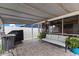 Cozy covered patio with a comfortable sofa, grill, and view into the screened in porch and home at 8719 Gaillard Ave, North Port, FL 34287