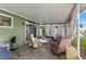 Covered porch features tile flooring, comfortable seating, and views of the backyard at 8719 Gaillard Ave, North Port, FL 34287