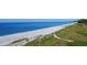 Panoramic beach view on a bright day with grassy dunes at 8779 Midnight Pass Rd # 406H, Sarasota, FL 34242