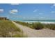 Scenic view of a sandy path through dune grass leading to a beautiful beach and ocean on a sunny day at 8779 Midnight Pass Rd # 406H, Sarasota, FL 34242