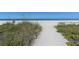 Sandy path leads to a sunny beach with calm ocean water at 8779 Midnight Pass Rd # 406H, Sarasota, FL 34242