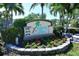 Attractive 'Island Reef' community sign with red flowers and shrubbery at 8779 Midnight Pass Rd # 406H, Sarasota, FL 34242