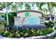 Welcoming community sign amidst lush landscaping, highlighting the property's address and rental options at 8779 Midnight Pass Rd # 406H, Sarasota, FL 34242