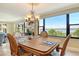 Dining room with bay view, carved chairs, and chandelier at 8779 Midnight Pass Rd # 406H, Sarasota, FL 34242