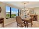 Dining room with chandelier, wood table, and bay view at 8779 Midnight Pass Rd # 406H, Sarasota, FL 34242