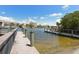 Waterfront view of a dock leading to waterfront condos against a partly cloudy blue sky at 8779 Midnight Pass Rd # 406H, Sarasota, FL 34242