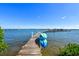 Dock with kayaks and boat slip access on the water with a clear blue sky, perfect for boating and enjoying waterfront living at 8779 Midnight Pass Rd # 406H, Sarasota, FL 34242