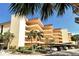 Multi-story condo building with palm trees, landscaping and covered parking spaces at 8779 Midnight Pass Rd # 406H, Sarasota, FL 34242