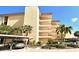 Condominium building with multi-level balconies surrounded by lush, tropical landscaping at 8779 Midnight Pass Rd # 406H, Sarasota, FL 34242