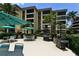 Outdoor seating and grilling area with lush landscaping and views of the building at 8779 Midnight Pass Rd # 406H, Sarasota, FL 34242