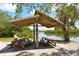 A shady picnic area overlooking a calm canal, perfect for enjoying outdoor meals and relaxing by the water at 8779 Midnight Pass Rd # 406H, Sarasota, FL 34242