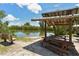 Picnic area featuring lake view, benches and picnic tables under a covered shelter at 8779 Midnight Pass Rd # 406H, Sarasota, FL 34242