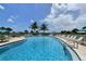 A curved pool with lounge chairs and tables offer a space to relax by the beach at 8779 Midnight Pass Rd # 406H, Sarasota, FL 34242