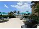 Pool area with lush landscaping, multiple tables with umbrellas, and community grills at 8779 Midnight Pass Rd # 406H, Sarasota, FL 34242