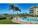 Exterior full view of the community pool near the beach with lounge chairs and tables for residents at 8779 Midnight Pass Rd # 406H, Sarasota, FL 34242