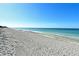 Wide sandy beach with clear blue waters and a tranquil horizon offers a peaceful and inviting coastal experience at 8779 Midnight Pass Rd # 406H, Sarasota, FL 34242