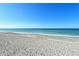 A wide sandy beach with calm, clear waters under a bright blue sky offers a relaxing coastal retreat at 8779 Midnight Pass Rd # 406H, Sarasota, FL 34242