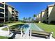Outdoor shuffleboard court with tropical landscaping in front of condos at 8779 Midnight Pass Rd # 406H, Sarasota, FL 34242