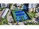 Overhead shot of the tennis and pickleball courts at the condo complex featuring lush landscaping and palm trees at 8779 Midnight Pass Rd # 406H, Sarasota, FL 34242