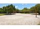 Volleyball court surrounded by mature trees and sand at 8779 Midnight Pass Rd # 406H, Sarasota, FL 34242
