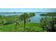 Scenic waterfront view showcasing lush greenery, tranquil waters, and clear blue skies enhancing the property's appeal at 8779 Midnight Pass Rd # 406H, Sarasota, FL 34242