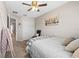 Well-lit bedroom with neutral colored walls, ceiling fan, double closet, and decor at 9743 Pembrooke Pines Dr, Sun City Center, FL 33573