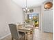 Bright dining room featuring a chandelier, large window, and a table set for six at 9743 Pembrooke Pines Dr, Sun City Center, FL 33573