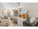 Cozy living room with plush sofas, ceiling fan, and open layout to kitchen, perfect for relaxation at 9743 Pembrooke Pines Dr, Sun City Center, FL 33573