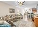 Spacious living room with a sectional sofa, ceiling fan, and open view to the adjacent dining area at 9743 Pembrooke Pines Dr, Sun City Center, FL 33573
