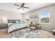 Bright main bedroom with decorative ceiling fan, comfy bed, chair and footstool near sunny windows at 9743 Pembrooke Pines Dr, Sun City Center, FL 33573