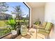 Cozy patio with green chairs, small table and view of the yard at 9743 Pembrooke Pines Dr, Sun City Center, FL 33573