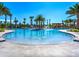 Resort-style pool with palm trees, fountains, and a shaded pergola provides a luxurious outdoor experience at 9743 Pembrooke Pines Dr, Sun City Center, FL 33573
