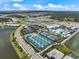 Aerial view of the community featuring tennis courts, a pool, a clubhouse, and several residences with lakes at 10240 Beach Dune Dr, Englewood, FL 34223