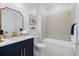 Stylish bathroom featuring a vanity with gold fixtures, bathtub, and tiled shower at 10240 Beach Dune Dr, Englewood, FL 34223