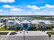 Beautiful aerial view of the community clubhouse with manicured landscaping and serene lake views at 10240 Beach Dune Dr, Englewood, FL 34223
