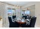 Dining room featuring a wood table, stylish chairs, and natural light from a large window at 10240 Beach Dune Dr, Englewood, FL 34223