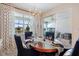 Dining area features a wood table, plush chairs, modern decor, and sliding glass doors at 10240 Beach Dune Dr, Englewood, FL 34223