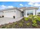 Beautiful one-story home boasts a paver driveway, colorful flowers, and lush, tropical landscaping at 10240 Beach Dune Dr, Englewood, FL 34223