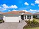 Charming single-story home with a tile roof, paver driveway, and beautifully landscaped front yard at 10240 Beach Dune Dr, Englewood, FL 34223