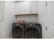 Laundry room with front-load washer/dryer and white cabinets at 10240 Beach Dune Dr, Englewood, FL 34223