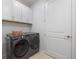 Well-equipped laundry room with modern appliances, cabinet storage, and bright lighting at 10240 Beach Dune Dr, Englewood, FL 34223