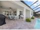 Beautiful covered patio with an outdoor dining table and additional seating overlooking the backyard and pool at 10240 Beach Dune Dr, Englewood, FL 34223