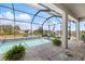 Inviting screened-in pool with patio seating, lush foliage, and relaxing ambiance at 10240 Beach Dune Dr, Englewood, FL 34223