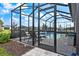 The screened-in pool area has a tranquil waterfall feature and comfortable lounge chairs at 10240 Beach Dune Dr, Englewood, FL 34223