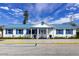 Exterior shot of the clubhouse with blue window shutters, matching roof, and sidewalk leading to entrance at 10315 Cortez W Rd # 32Bv, Bradenton, FL 34210