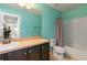 Bright bathroom features a single sink vanity, mirror, tub and shower combo, and turquoise colored walls at 11212 58Th Street E Cir, Parrish, FL 34219