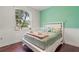 Bright bedroom with mint accent wall, white trim, and large window overlooking the backyard at 12710 Rockrose Gln, Lakewood Ranch, FL 34202